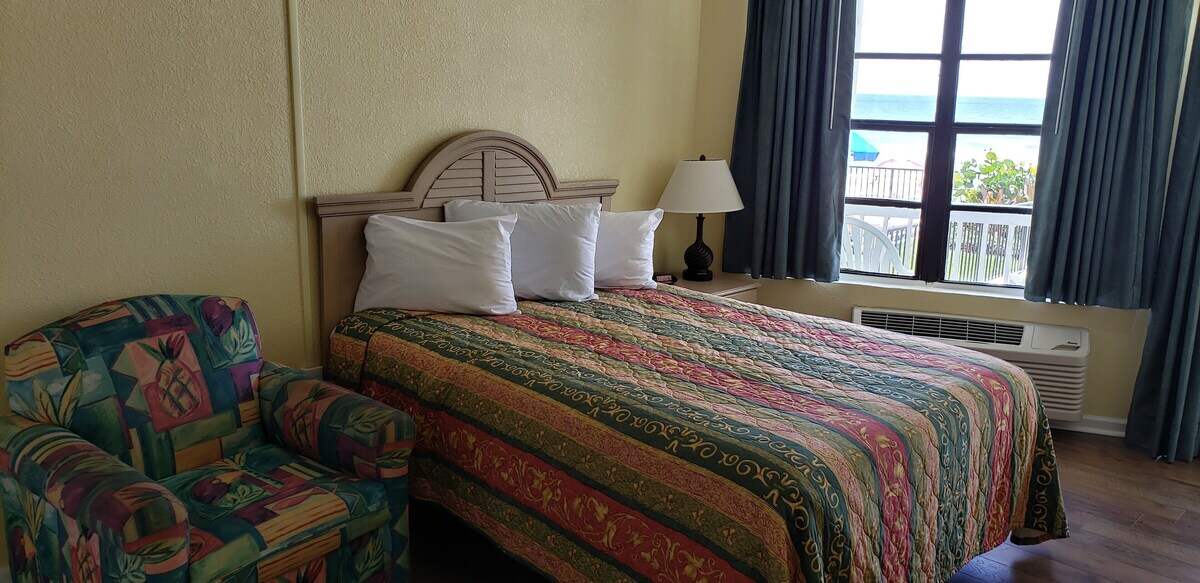 Guest room with two beds and ocean view window